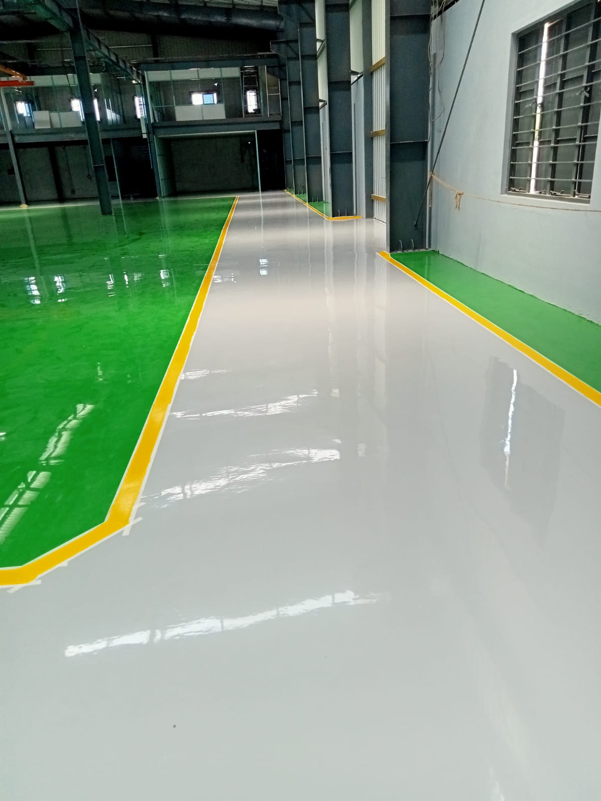 Power Coats finished epoxy floor with green bays and grey walkway on a client site